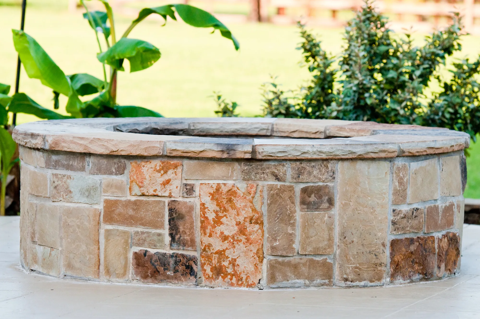 Built-in fire pit surrounded by paving and garden beds