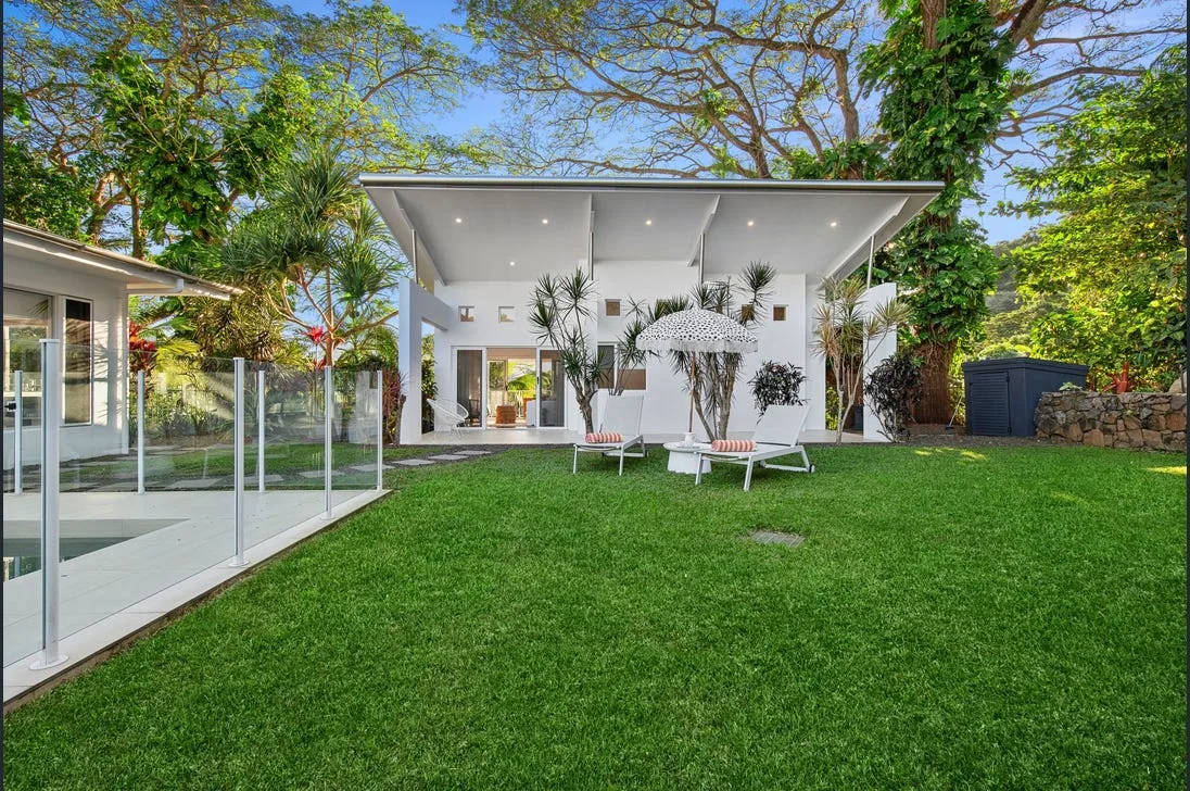 Landscaped family backyard with lawn, garden beds and paved area