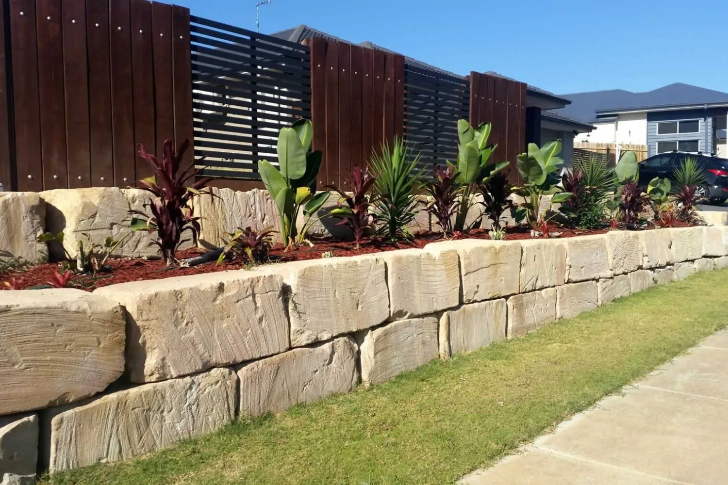 Sandstone block retaining wall with tropical garden planting