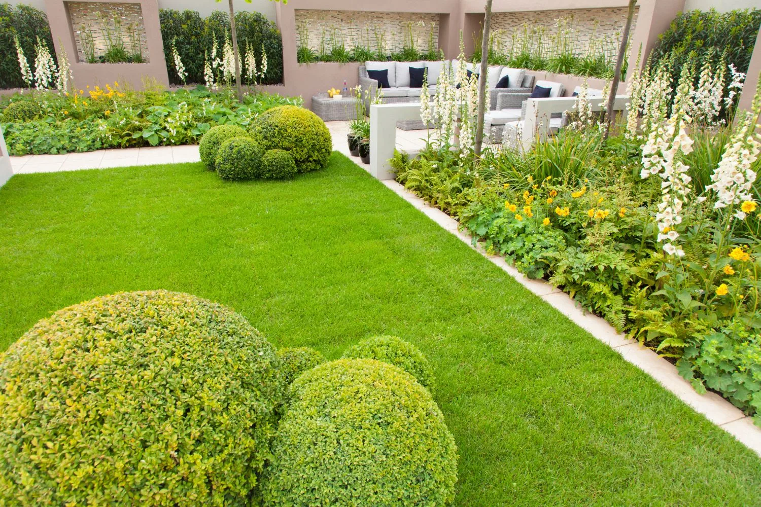 Landscaped backyard with lawn, garden beds and outdoor lounge