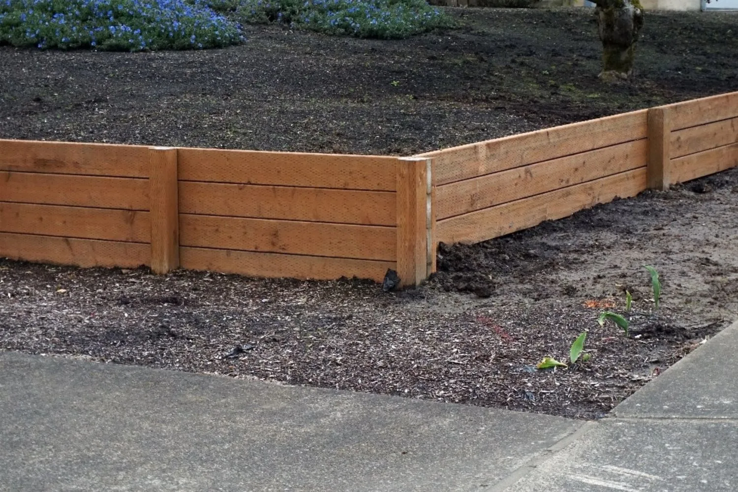Treated pine sleeper retaining wall corner beside a garden bed